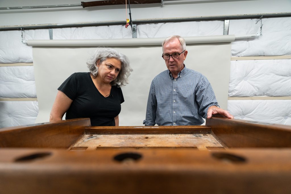 Carmina Mortillaro, Collections Specialist at Space Center Houston, and Pine examine the lectern at his conservation lab. / Photograph by Aaron Rodriguez