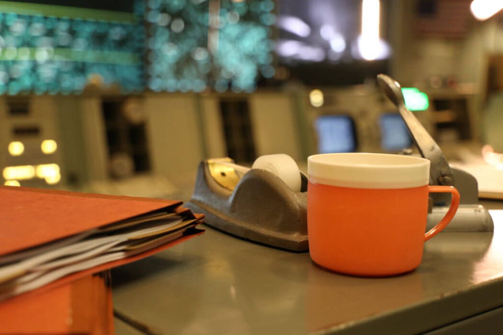 A visit to the restored Apollo Mission Control Center is a must see at Space Center Houston. Inside the room, furnishings on the consoles, flight control manuals, ashtrays, coffee cups and headsets, depict an accurate look of the iconic room based on the Apollo era.